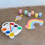 Picture of the chalk paints mixed in the tray and a colorful rainbow and a purple planet with yellow ring are painted on the concrete.