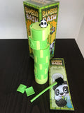 green game tower with cute panda sitting on top.  a couple leaf game pieces on the table with the panda paw basher stick