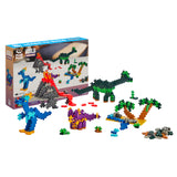 Box in background with assembled pieces in front, including a blue raptor, a green sauropod, and a purple triceratops as well as a volcano and oasis.