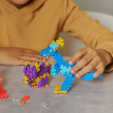 Closeup of child playing with the assembled dinosaur figures.