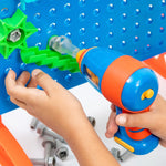 Closeup of child using the power drill to bolt on a section of the marble maze to the backer board.