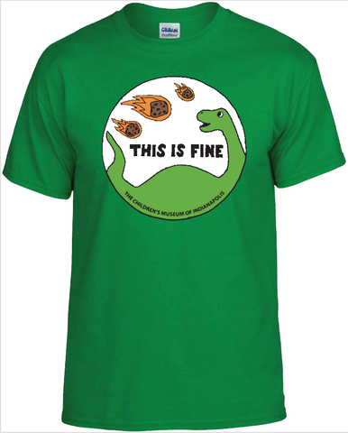Green tee shirt with a circular print on the front.  Print illustrates a cartoon long neck dinosaur watching flaming meteors fall from the sky.  The words "This Is Fine" are across the center of the image.  Curved across the bottom of the circular image is "The Children's Museum of Indianapolis".